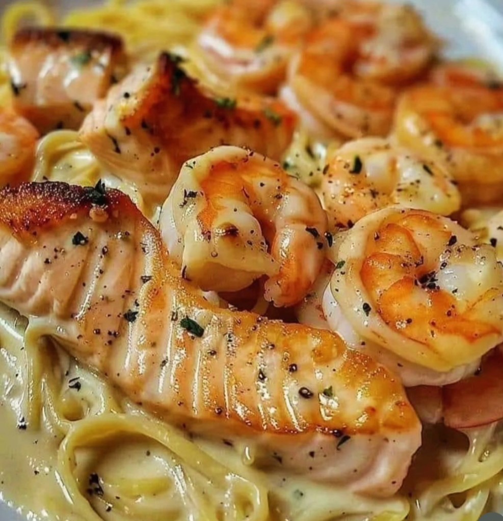 Creamy seafood pasta with grilled salmon and shrimp