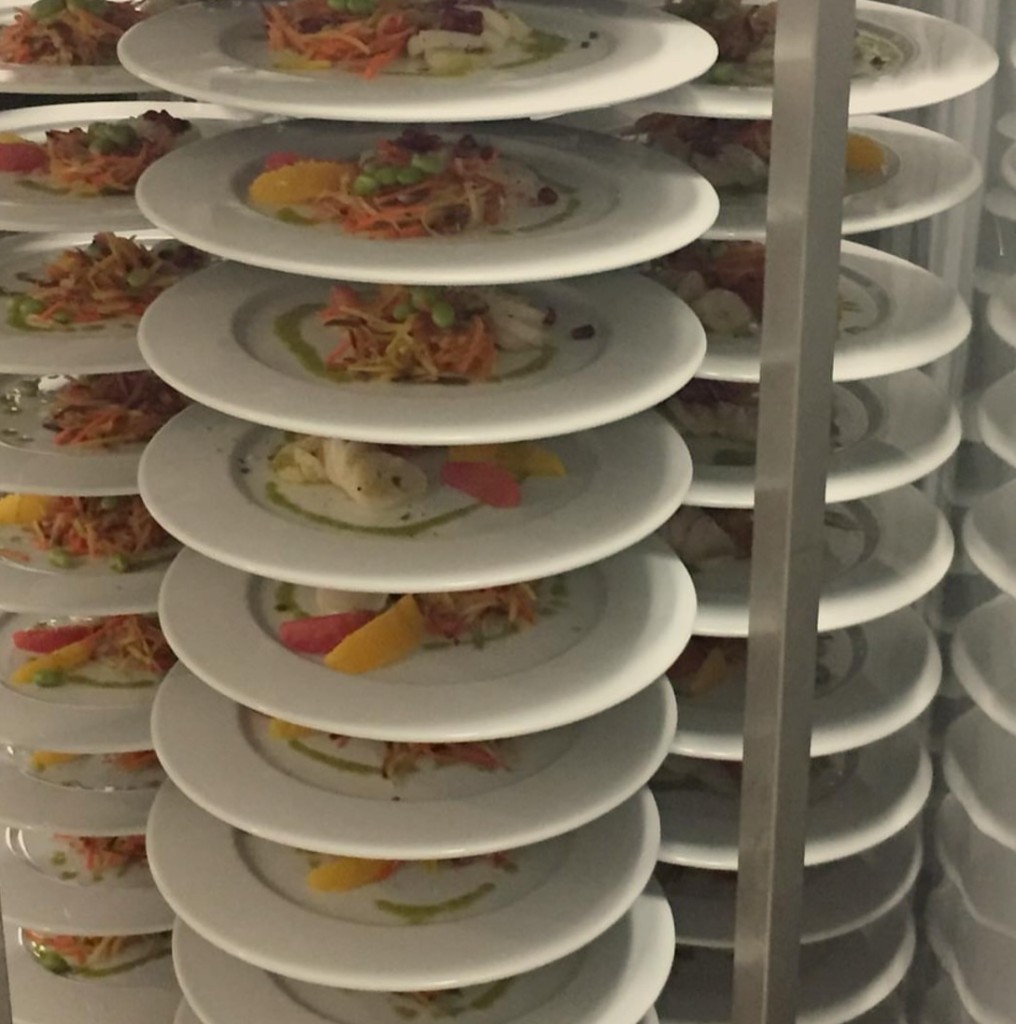 Stacked gourmet plates awaiting event service